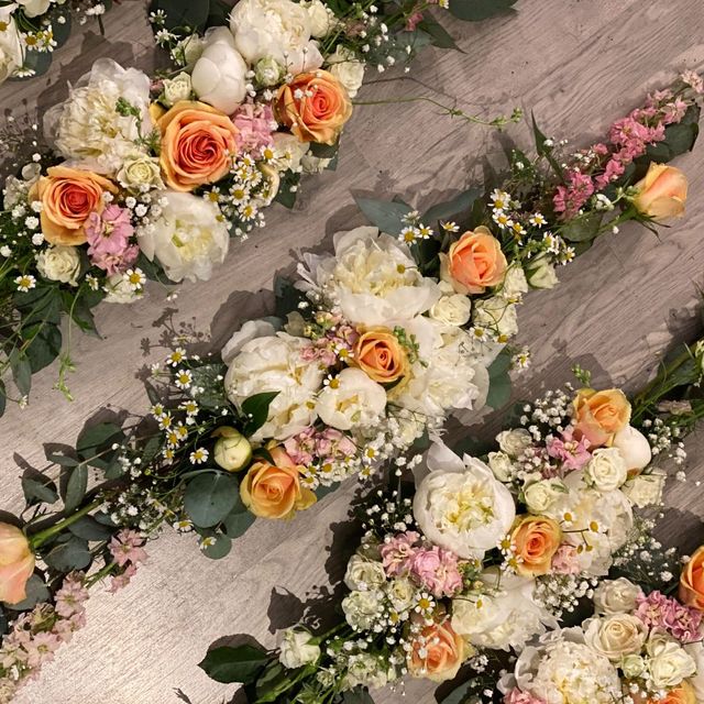 Borddekorasjoner med oransje, hvite, og rosa blomster