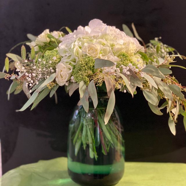 Grønn glassvase med blomster